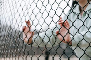 caos interiore, donna dietro una recinzione