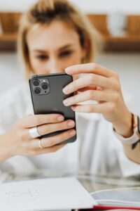 FOMO: donna che scorre il telefono di sera, a letto